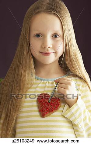 Young Holding Heart Shaped Cookie In Studio View Large Photo Image Stock Photo - Young Holding Heart Shaped Cookie In Studio. Fotosearch