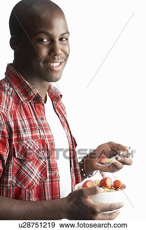 Young Man Eating Bowl Of Healthy Breakfast Cereal In Studio View Large Photo Image Stock Photo - Young Man Eating Bowl Of Healthy Breakfast Cereal In Studio. Fotosearch
