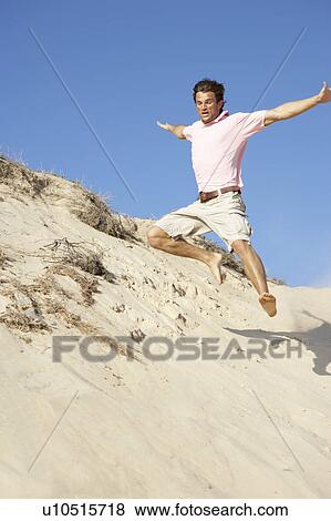 Young Man Enjoying Beach Holiday Running Down Dune View Large Photo Image Stock Photo - Young Man Enjoying Beach Holiday Running Down Dune. Fotosearch