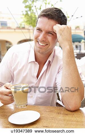 Stock Photo - Young Man Enjoying Cup Of Coffee In Café. Fotosearch