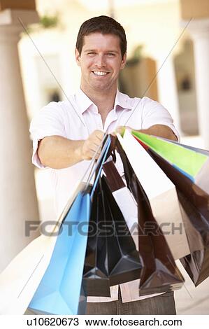 Stock Image - Young Man Enjoying Shopping Trip . Fotosearch