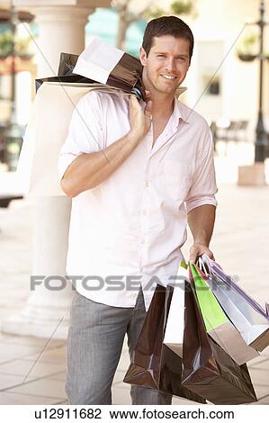 Stock Image - Young Man Enjoying Shopping Trip . Fotosearch