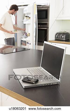 Young Man Fixing Snack In Kitchen With Laptop In Modern Kitchen View Large Photo Image Stock Image - Young Man Fixing Snack In Kitchen With Laptop In Modern Kitchen . Fotosearch