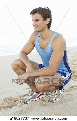 Young Man In Fitness Clothing Resting After Exercise On Beach View Large Photo Image Stock Photo - Young Man In Fitness Clothing Resting After Exercise On Beach. Fotosearch
