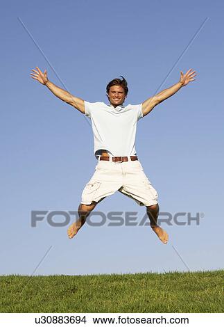 Picture - Young man jumping in air. Fotosearch