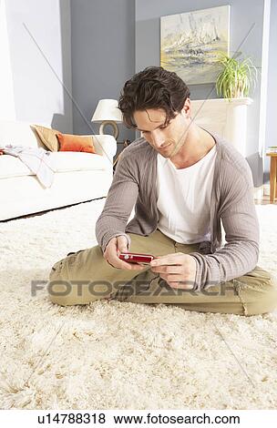 Young Man Looking At Photograph On Digital Camera At Home View Large Photo Image Stock Photo - Young Man Looking At Photograph On Digital Camera At Home . Fotosearch
