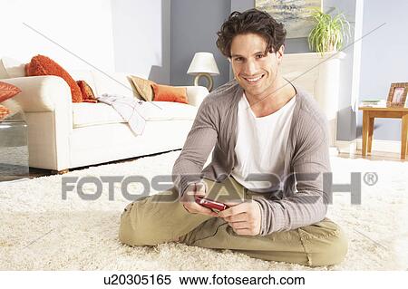 Young Man Looking At Photograph On Digital Camera At Home View Large Photo Image Stock Photography - Young Man Looking At Photograph On Digital Camera At Home . Fotosearch