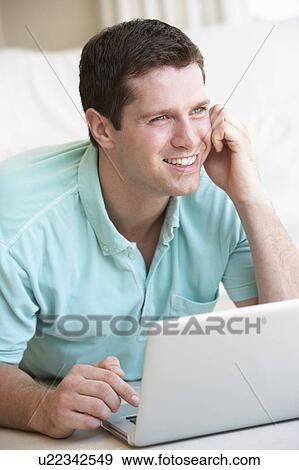 Stock Photo - Young man on his laptop computer. Fotosearch
