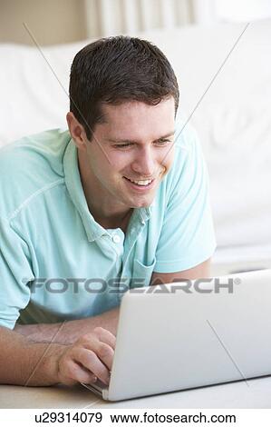 Young man on his laptop computer View Large Photo Image Stock Photo - Young man on his laptop computer. Fotosearch
