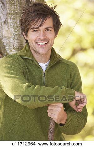 Picture - Young Man Outdoors Walking In Autumn Woodland Holding Walking Stick. Fotosearch