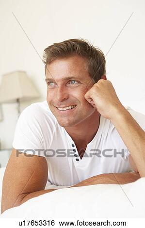 Stock Photograph - Young Man Relaxing On Bed. Fotosearch