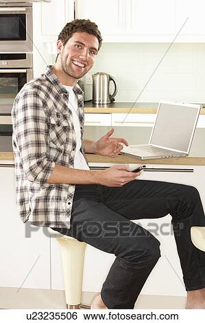 Young Man Relaxing Sitting In Kitchen Talking On Phone View Large Photo Image Stock Photograph - Young Man Relaxing Sitting In Kitchen Talking On Phone. Fotosearch