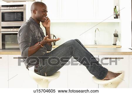 Young Man Relaxing Sitting In Kitchen Talking On Phone View Large Photo Image Stock Photography - Young Man Relaxing Sitting In Kitchen Talking On Phone. Fotosearch