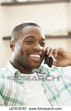 Young Man Relaxing Sitting On Sofa At Home Talking On Phone View Large Photo Image Stock Photo - Young Man Relaxing Sitting On Sofa At Home Talking On Phone. Fotosearch