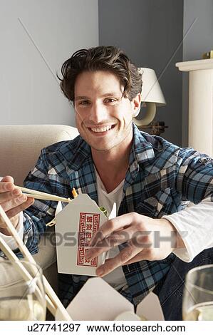 Young Man Relaxing Sitting On Sofa At Eating Chinese Meal At Home View Large Photo Image Stock Photo - Young Man Relaxing Sitting On Sofa At Eating Chinese Meal At Home . Fotosearch