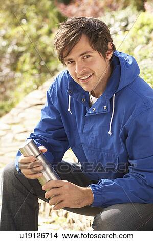 Young Man Relaxing With Thermos Flask In Autumn Landscape View Large Photo Image Picture - Young Man Relaxing With Thermos Flask In Autumn Landscape. Fotosearch