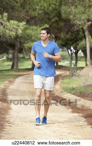 Stock Image - Young man running in park. Fotosearch