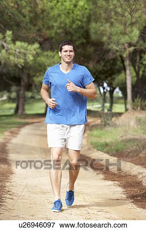Young man running in park View Large Photo Image Stock Photo - Young man running in park. Fotosearch
