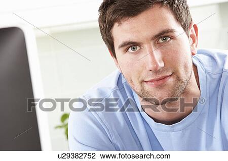Young Man Using Computer In Modern Kitchen View Large Photo Image Stock Image - Young Man Using Computer In Modern Kitchen . Fotosearch