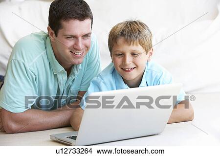 Young man with child on laptop computer View Large Photo Image Picture - Young man with child on laptop computer. Fotosearch