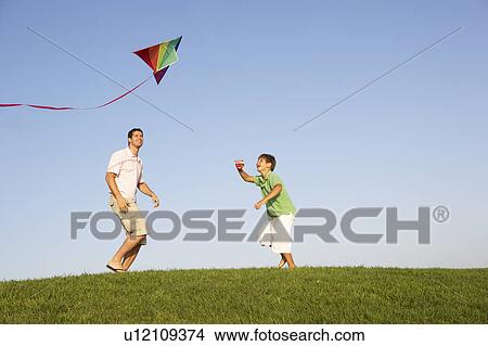 Picture - Young parent, father with child, playing in a field. Fotosearch