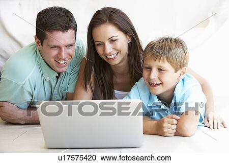 Stock Image - Young parents, with child, on laptop computer. Fotosearch