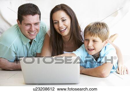 Stock Image - Young parents, with child, on laptop computer. Fotosearch