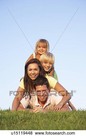 Young parents, with children, posing on a field View Large Photo Image Stock Photo - Young parents, with children, posing on a field. Fotosearch