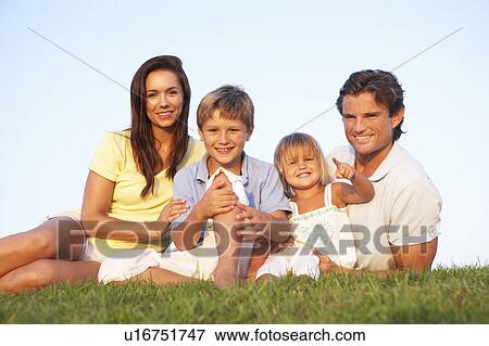Young parents, with children, posing on a field View Large Photo Image Stock Photo - Young parents, with children, posing on a field. Fotosearch