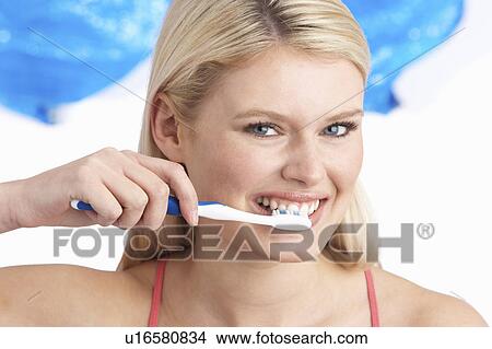 Young Woman Brushing Teeth In Studio View Large Photo Image Picture - Young Woman Brushing Teeth In Studio. Fotosearch
