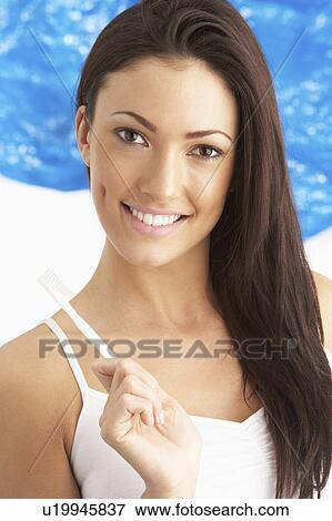 Young Woman Brushing Teeth In Studio View Large Photo Image Stock Photo - Young Woman Brushing Teeth In Studio. Fotosearch