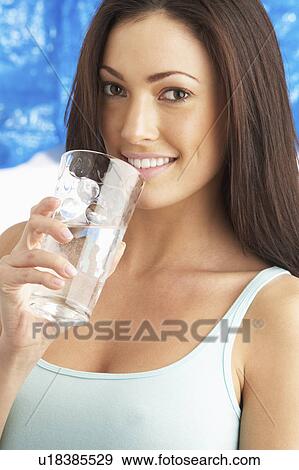 Stock Photo - Young Woman Drinking Glass Of Water In Studio. Fotosearch