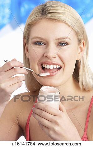 Young Woman Eating Yoghurt In Studio View Large Photo Image Picture - Young Woman Eating Yoghurt In Studio. Fotosearch