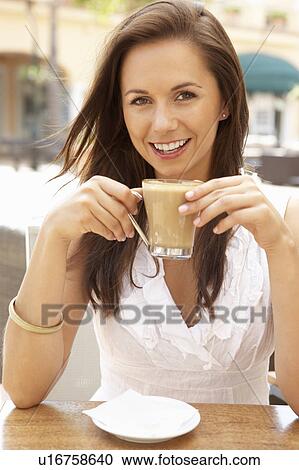 Stock Image - Young Woman Enjoying Cup Of Coffee In Café. Fotosearch