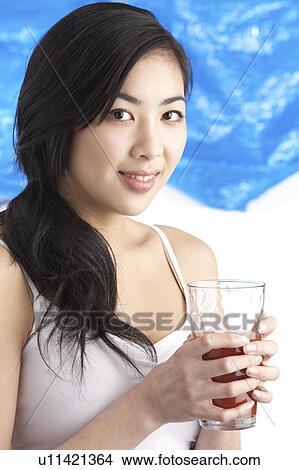 Picture - Young Woman Enjoying Healthy Drink In Studio. Fotosearch