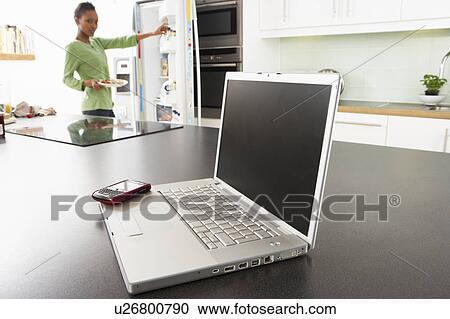 Young Woman Fixing Snack In Kitchen With Laptop In Modern Kitchen View Large Photo Image Stock Image - Young Woman Fixing Snack In Kitchen With Laptop In Modern Kitchen . Fotosearch