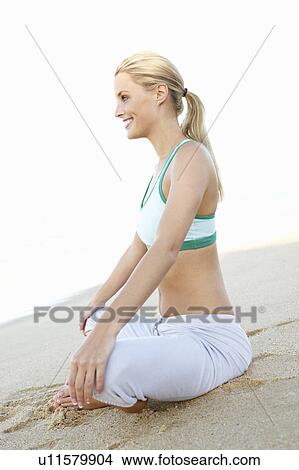 Young Woman In Fitness Clothing Resting After Exercise On Beach View Large Photo Image Picture - Young Woman In Fitness Clothing Resting After Exercise On Beach. Fotosearch