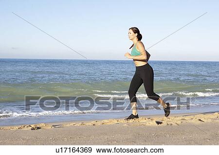 Young Woman In Fitness Clothing Running Along Beach View Large Photo Image Stock Photo - Young Woman In Fitness Clothing Running Along Beach. Fotosearch