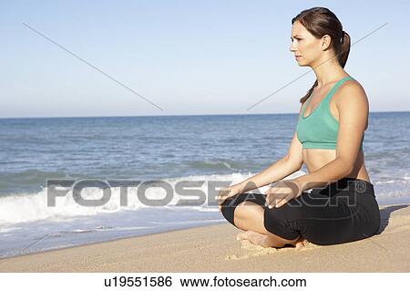 Young Woman In Fitness Clothing Meditating On Beach View Large Photo Image Stock Photograph - Young Woman In Fitness Clothing Meditating On Beach. Fotosearch