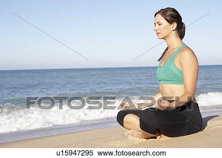 Young Woman In Fitness Clothing Meditating On Beach View Large Photo Image Stock Photography - Young Woman In Fitness Clothing Meditating On Beach. Fotosearch