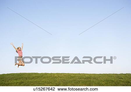 Young woman jumping in air View Large Photo Image Stock Image - Young woman jumping in air. Fotosearch