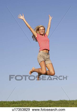 Young woman jumping in air View Large Photo Image Stock Photo - Young woman jumping in air. Fotosearch