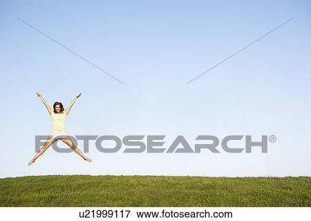 Stock Photo - Young woman jumping in air. Fotosearch
