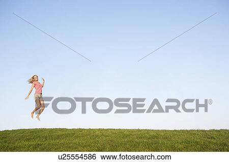 Young woman jumping in air View Large Photo Image Stock Photograph - Young woman jumping in air. Fotosearch