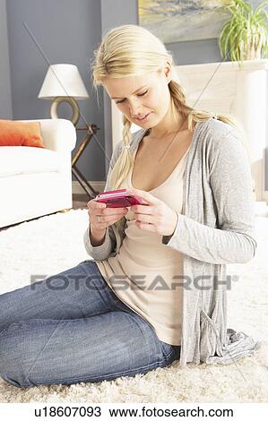 Stock Image - Young Woman Looking At Photograph On Digital Camera At Home . Fotosearch