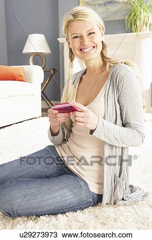 Stock Image - Young Woman Looking At Photograph On Digital Camera At Home . Fotosearch