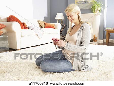 Stock Photograph - Young Woman Looking At Photograph On Digital Camera At Home . Fotosearch