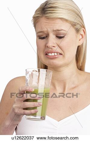 Stock Photo - Young Woman Not Enjoying Healthy Drink In Studio. Fotosearch
