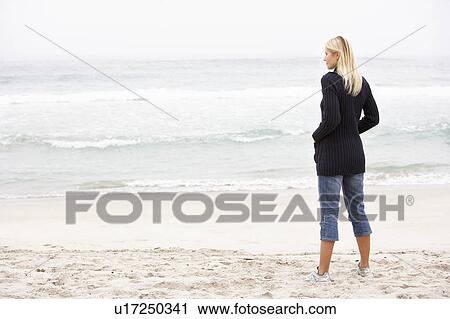 Young Woman On Holiday Standing On Winter Beach View Large Photo Image Stock Image - Young Woman On Holiday Standing On Winter Beach. Fotosearch