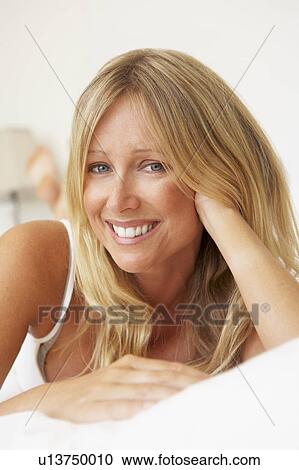 Stock Image - Young Woman Relaxing On Bed. Fotosearch